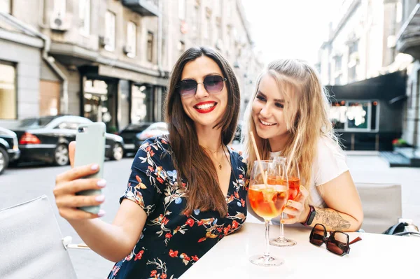 Jovens meninas bonitas leva selfie em um café ao ar livre — Fotografia de Stock