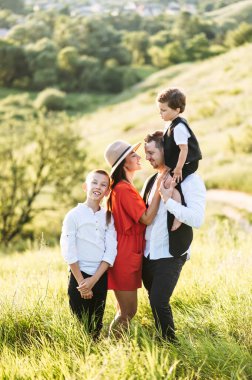 Mutlu ve sevgi dolu aile sahada duruyor.
