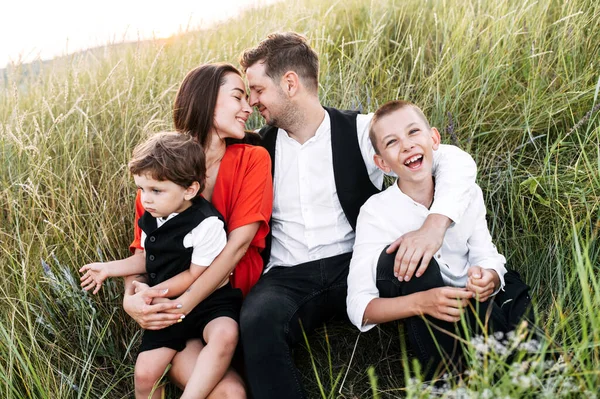 Família feliz de quatro pessoas no campo — Fotografia de Stock