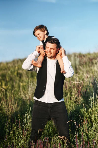 Вертикальний знімок молодого чоловіка з хлопчиком на плечах — стокове фото