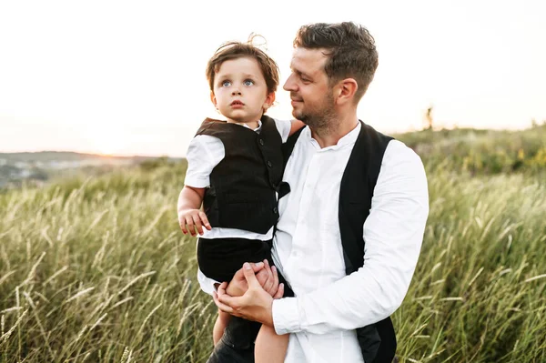 Un père tient son petit fils dans ses bras à l'extérieur — Photo