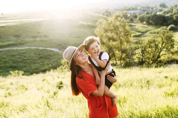 Midshot av glada mamma och son på ett soligt fält — Stockfoto
