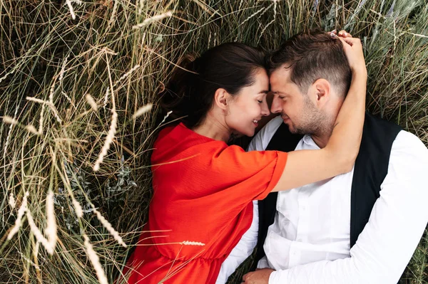 Pareja enamorada entre hierba alta en el prado —  Fotos de Stock