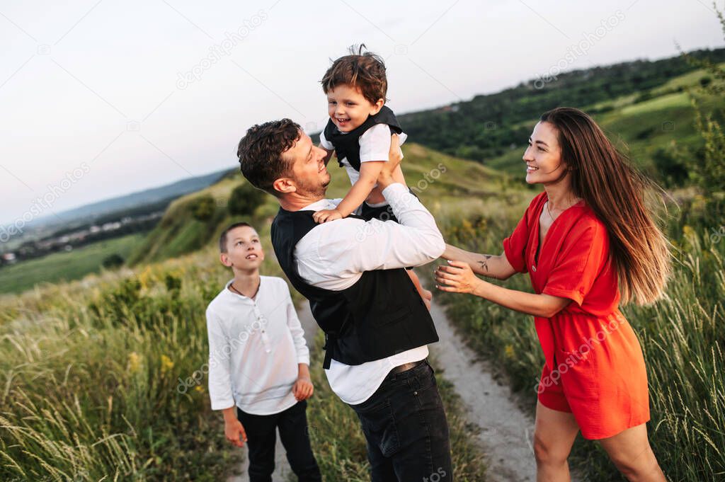 Happy family of four in the countryside