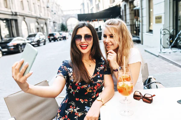 Jovens meninas bonitas leva selfie em um café ao ar livre — Fotografia de Stock