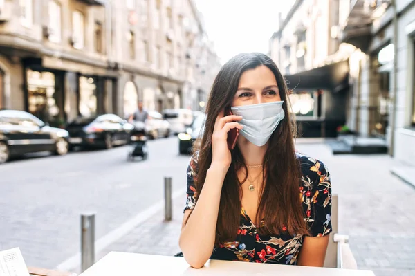 Mädchen in medizinischer Maske verbringt Zeit im Café — Stockfoto