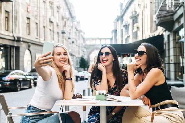 Unga vackra flickor sitter i ett café utomhus — Stockfoto