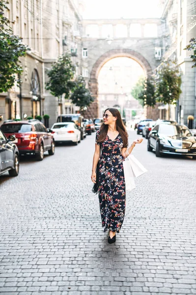 Chica alegre con bolsas de compras camina al aire libre — Foto de Stock