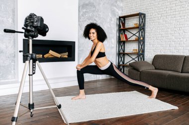 Afro-Amerikalı bir kadın yoga dersleri kaydediyor.