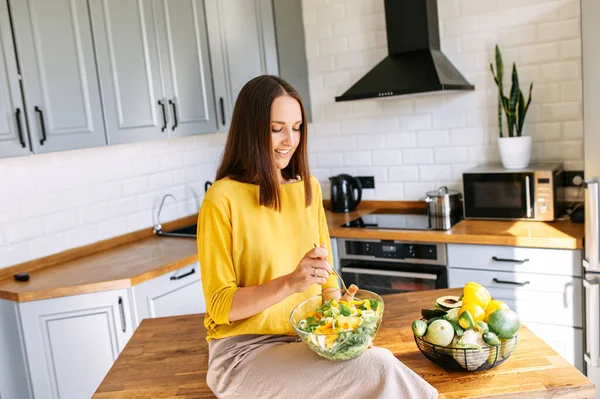 Una donna attraente mangia insalata fresca — Foto Stock