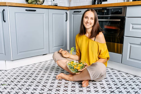 Una donna attraente mangia insalata fresca — Foto Stock