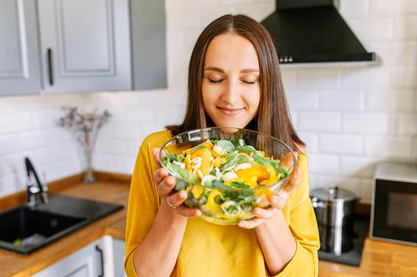 Una donna attraente con una ciotola di insalata fresca — Foto Stock