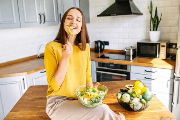 Una donna attraente mangia insalata fresca — Foto Stock