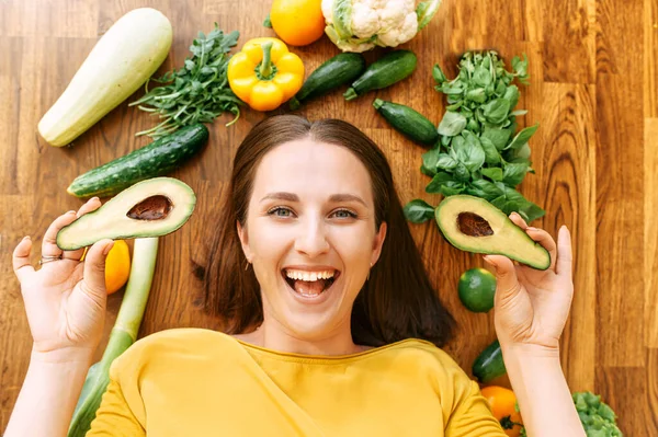 Een vrouw ligt omringd met verse groenten — Stockfoto