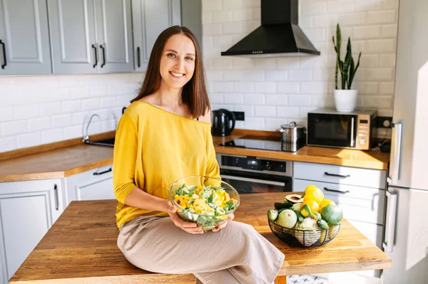 Una donna attraente mangia insalata fresca — Foto Stock