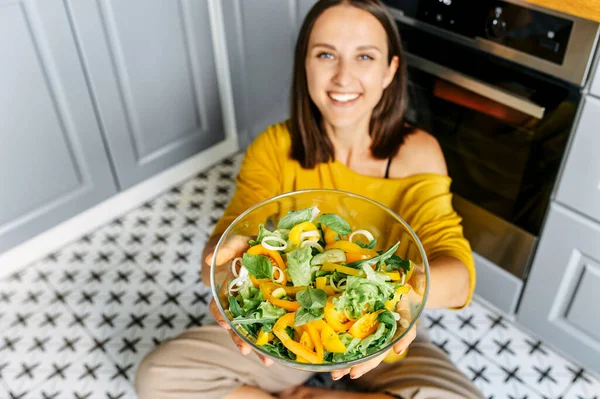 Una donna preda tiene un pizzico di insalata — Foto Stock