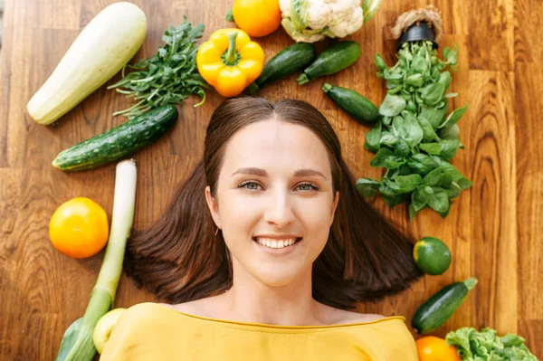 Een vrouw ligt omringd met verse groenten — Stockfoto