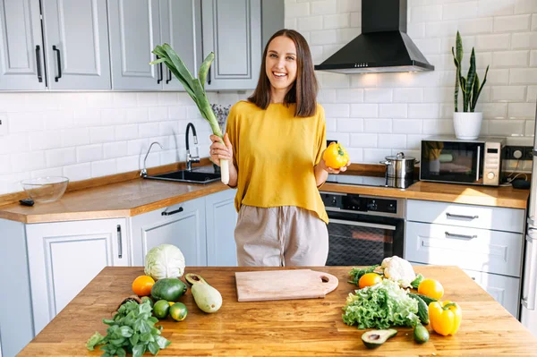 Uma mulher alegre está preparando uma salada — Fotografia de Stock