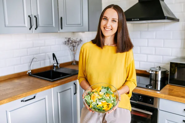Una donna attraente con una ciotola di insalata fresca — Foto Stock