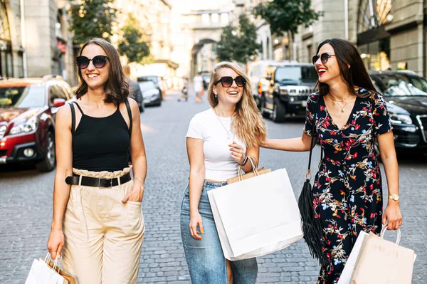 Tre kvinnelige venner går etter shopping – stockfoto