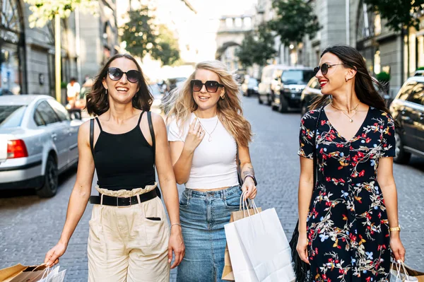 Three female friends walk after shopping — Stock Photo, Image