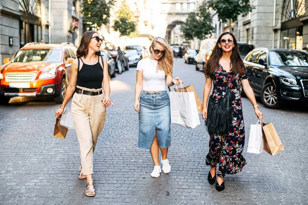 Tre kvinnliga vänner går efter shopping — Stockfoto