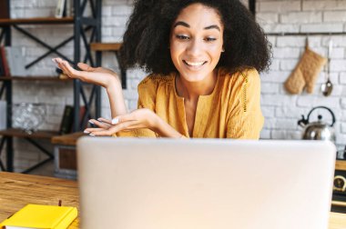 Afrikalı bir kız evde video görüşmesi için laptop kullanıyor.