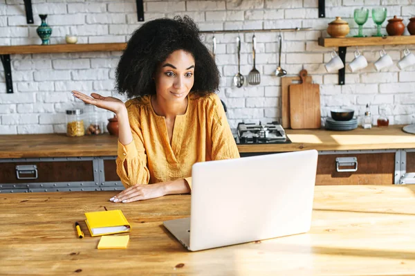 Uma menina africana usa laptop para videochamada em casa — Fotografia de Stock