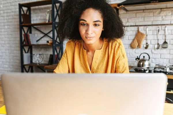 Una chica utiliza el ordenador portátil para el trabajo remoto o el ocio en casa —  Fotos de Stock