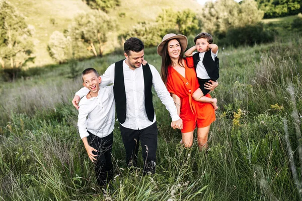 Longo tiro de uma família feliz lá fora na natureza — Fotografia de Stock