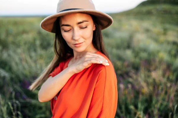 Hermosa mujer en sombrero camina en el campo de flores — Foto de Stock