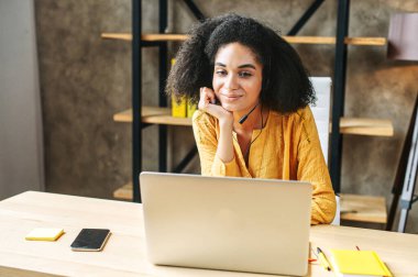 Elleri kulaklığı olmayan Afro-Amerikalı bir kadın.