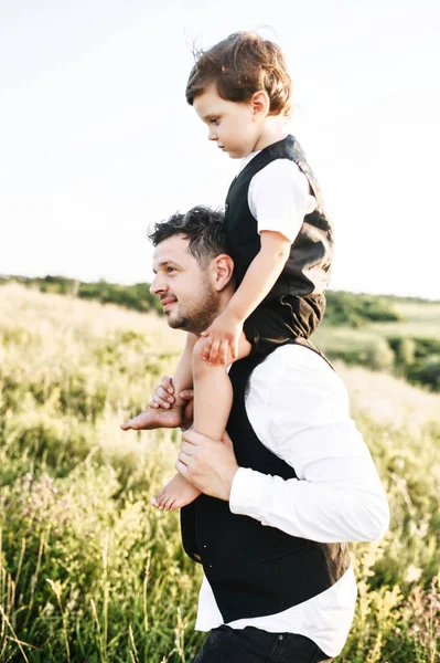 Jovem pai com um filho mais velho em seus ombros — Fotografia de Stock