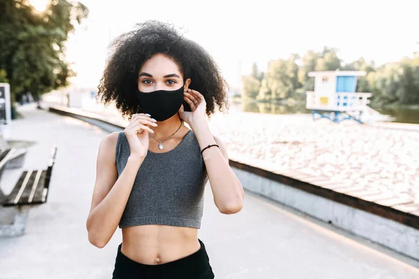 Afro-americano ragazza in maschera è jogging all'aperto — Foto Stock
