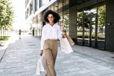 Melez bir genç kadın alışveriş yapıyor.