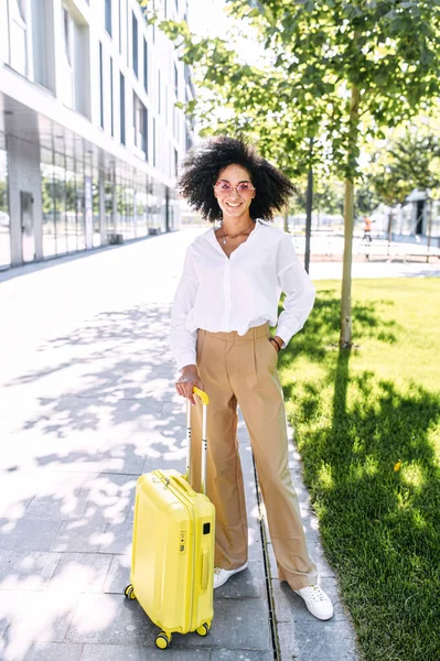 Una mujer hermosa con una maleta al aire libre — Foto de Stock