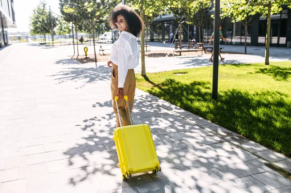 Una mujer hermosa con una maleta al aire libre — Foto de Stock