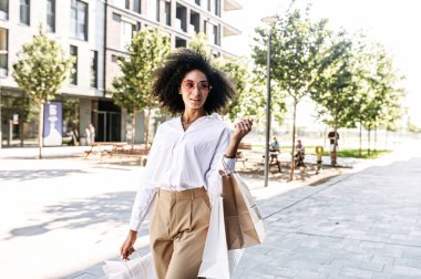 Melez bir genç kadın alışveriş yapıyor.