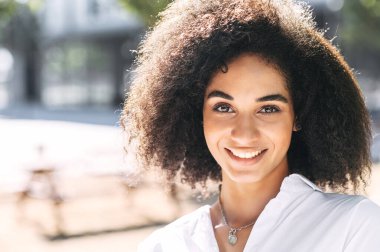 Saçları kıvırcık, güzel bir kız.