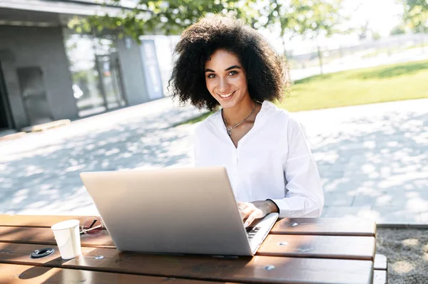 Una mujer que usa una computadora portátil para trabajar al aire libre —  Fotos de Stock