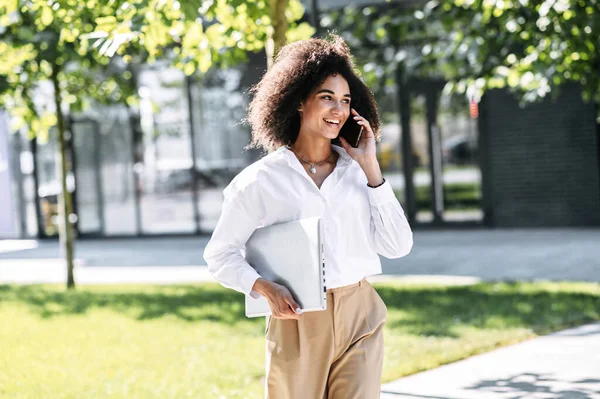 Una mujer está hablando por teléfono al aire libre — Foto de Stock