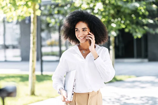 En kvinna pratar i telefon utomhus. — Stockfoto