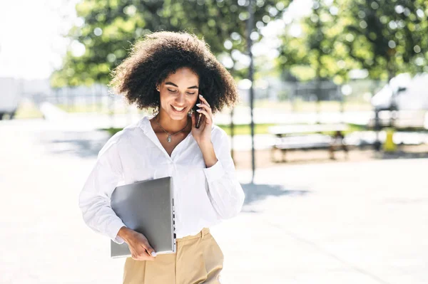 En kvinna pratar i telefon utomhus. — Stockfoto