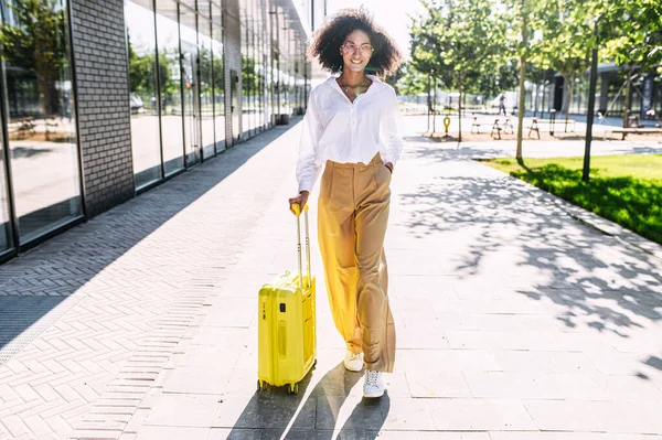 Una mujer hermosa con una maleta al aire libre — Foto de Stock