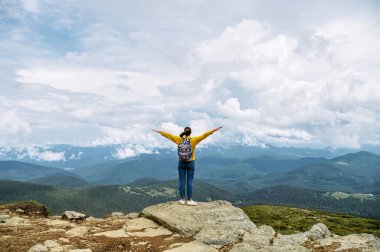 Dişi yürüyüşçü, dağ manzarasının keyfini çıkarıyor.