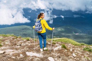 Kuzeyli yürüyüşü için sopalı bir kadın yürüyüşçü.