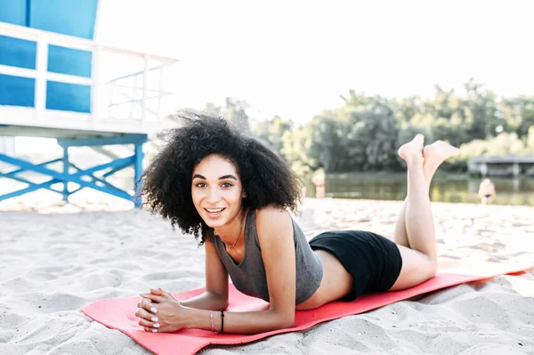 Соціальна дівчина в спортивному одязі на килимку на відкритому повітрі — стокове фото