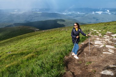 Kuzeyli yürüyüşü için sopalı bir kadın yürüyüşçü.