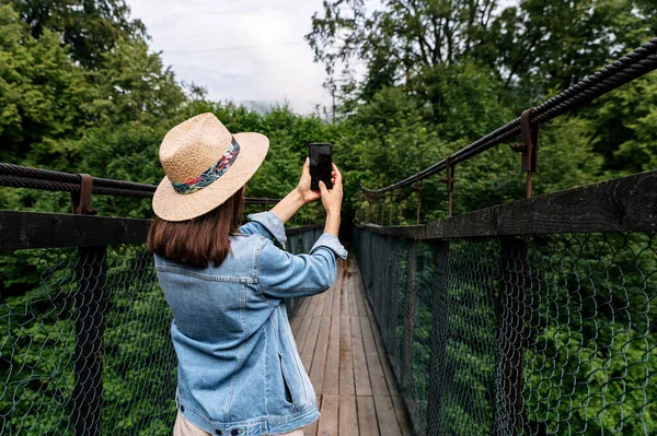 Uma garota viajante tira uma foto no smartphone — Fotografia de Stock