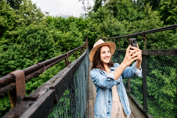 Uma garota viajante tira uma foto no smartphone — Fotografia de Stock